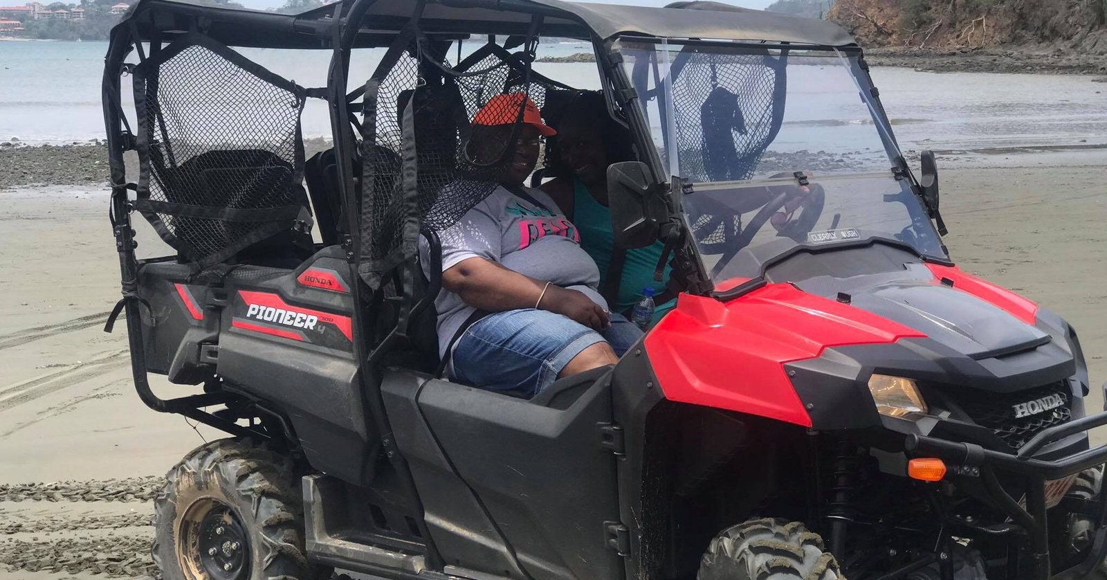 "Group of adventurers riding UTV side-by-side vehicles through the rugged trails of Tamarindo, surrounded by lush jungle and scenic coastal views."
