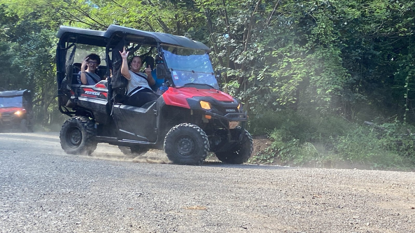 Group of adventurers riding UTV side-by-side vehicles through the rugged trails of Tamarindo, surrounded by lush jungle and scenic coastal views."